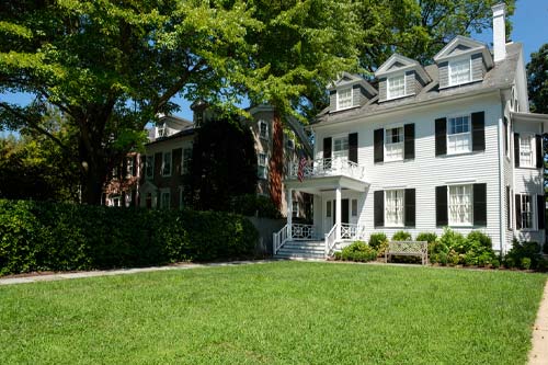 Angled front lawn view of a home with white siding.
