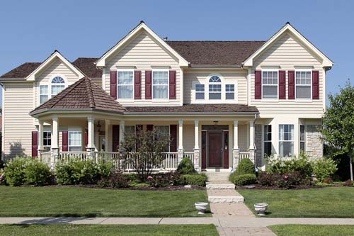 Off-white siding on home with red panel windows.